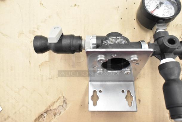 Metal fixture with attached pressure gauge and black fittings, part of a lot of diverse items including kitchen tools and hardware.