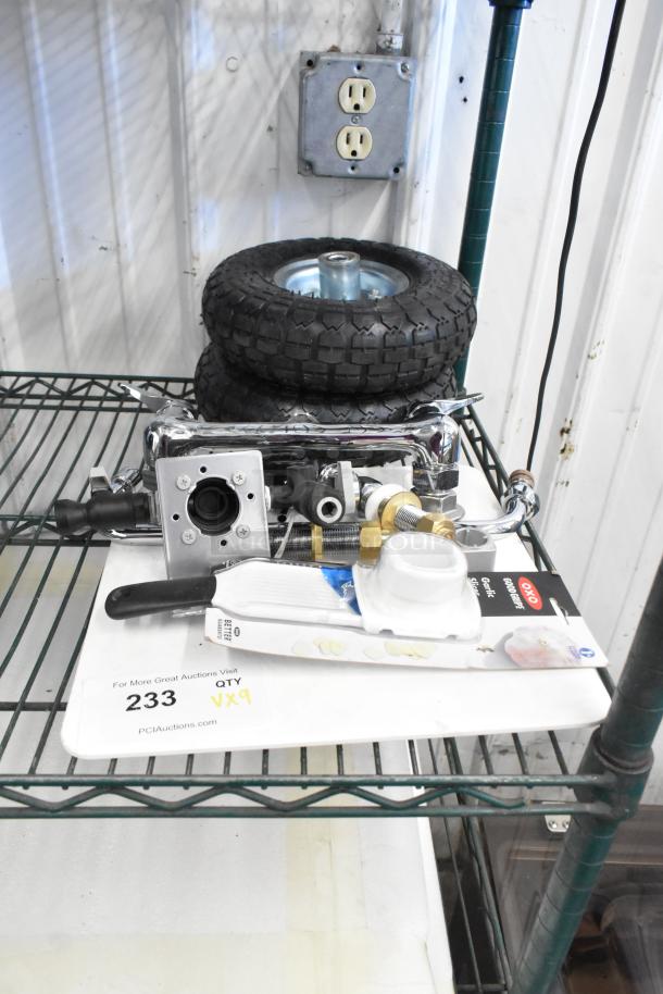Assorted lot of items including two tires, chrome faucet, and OXO garlic slicer, in good condition. Quantity: 9.
