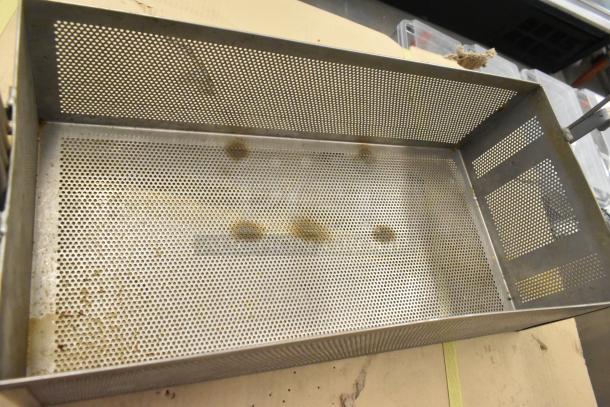 Two perforated metal fry baskets with rectangular shape; shows signs of use. Ideal for kitchen or restaurant use.