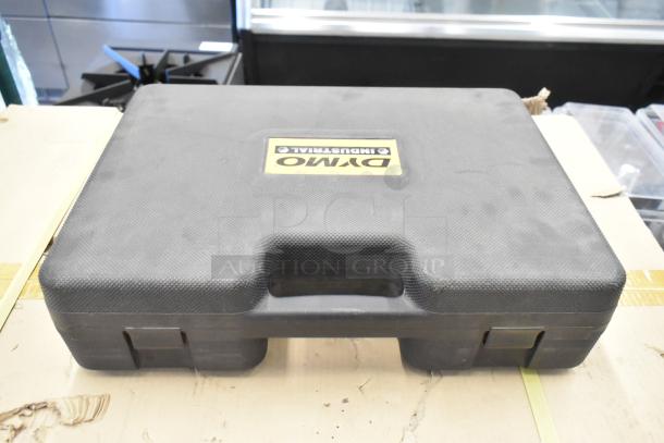 Dymo RhinoPro 5000 Label Printer in black hard case with handle, featuring Dymo branding on the lid.