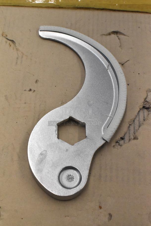 Silver S blade for food processor with a hexagonal center hole, on cardboard. In good condition.