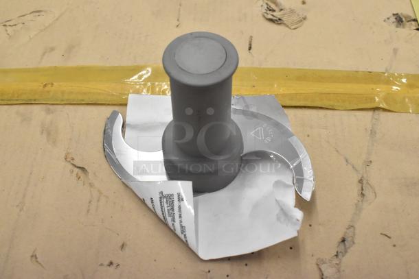 S blade for food processor, metal with plastic center, worn condition, includes label with product details.