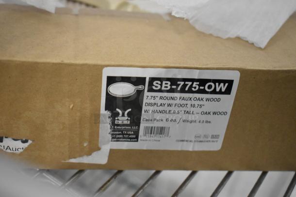 Box labeled "SB-775-OW," containing 7.75" round faux oak wood displays, 6 pieces, with product details and barcode.