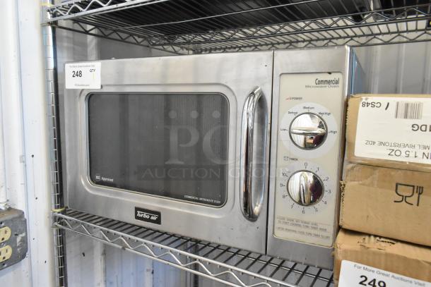 Turbo Air DHHS CODE H7NF stainless steel commercial microwave oven, 120V, 1 phase, with control dials, mounted on a shelf.