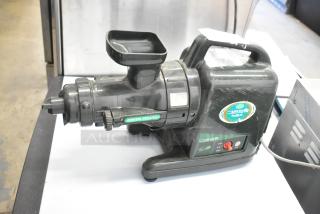 Countertop juice extractor, black, "Green Power" label, functional buttons, used condition, visible wear.