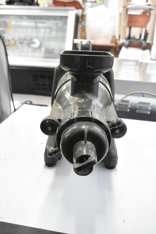 Countertop juice extractor, black, pre-owned, visible control knobs, compact design, ideal for home juicing.