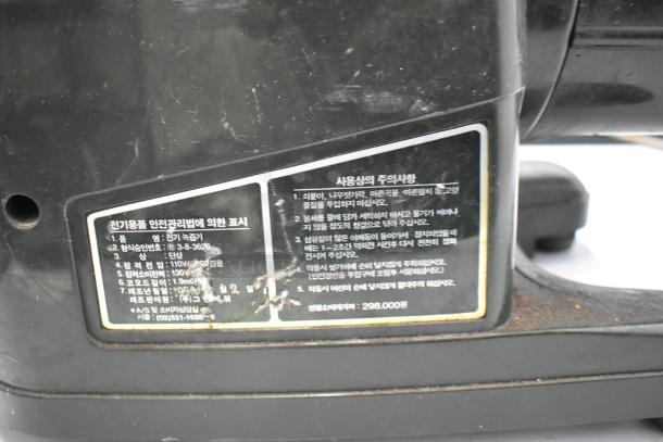 Countertop Juice Extractor, black, with visible label containing specifications and care instructions in Korean. Worn condition.