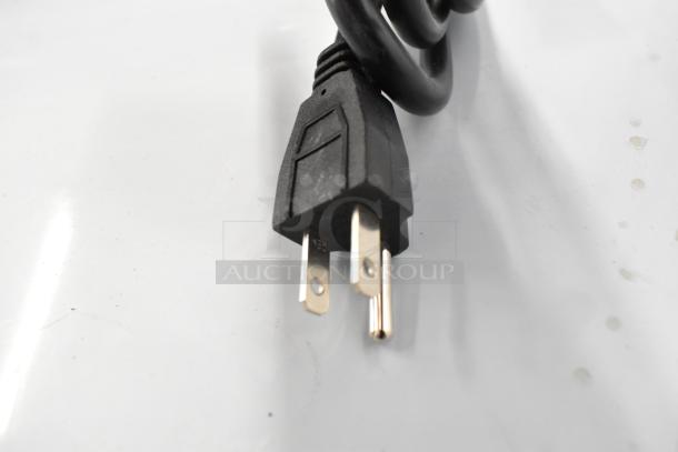 Close-up of a black power plug attached to a coiled cord, part of the Avantco 194MCH430A ice machine.