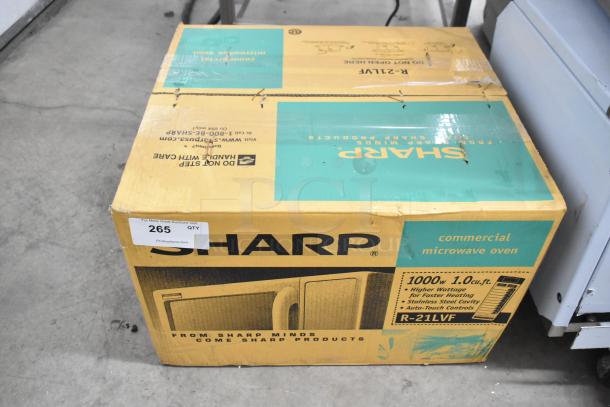 Unopened box of 2021 Amana RCS10TS stainless steel commercial microwave oven. Box shows product details and branding.