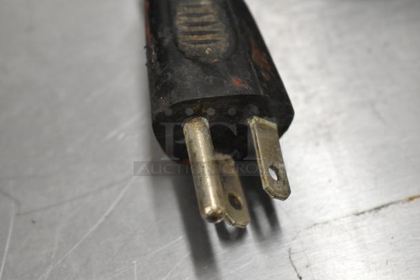 Plug of a metal commercial countertop espresso bean grinder, 115 volts, 1 phase, showing signs of wear.