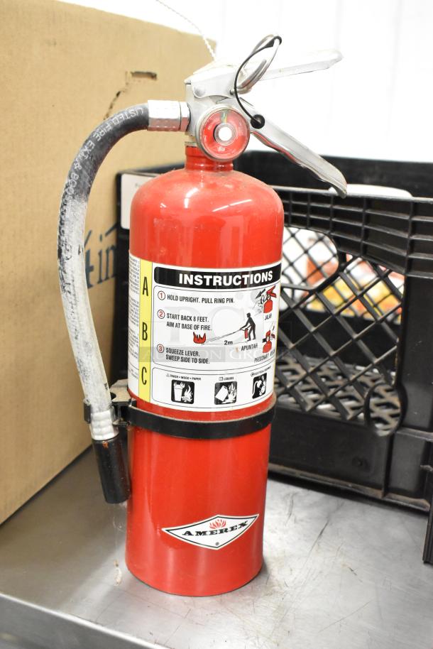 Red Amerex fire extinguisher with instructions label, hose attached. Sold as a lot of 5. Buyer pick-up required.