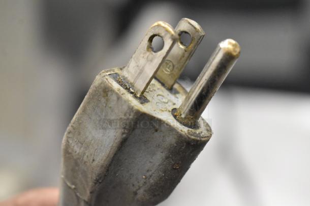 Close-up of a worn electrical plug from a 2016 Bizerba GSP H metal commercial countertop meat slicer, 120 volts, 1 phase.