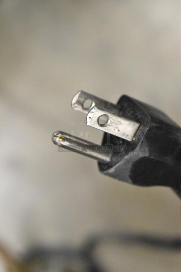Close-up of a three-prong electrical plug for Bunn CWTF15 coffee machine.