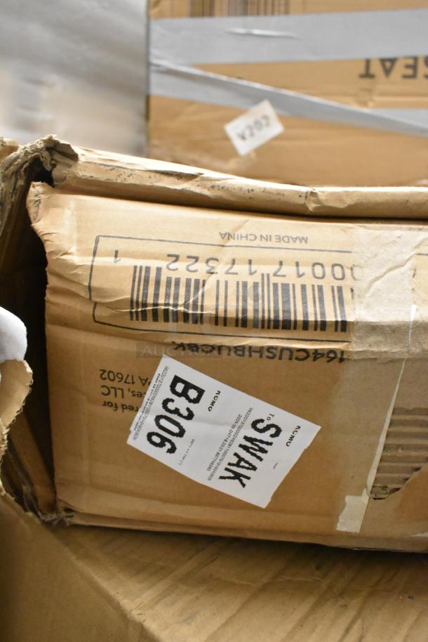 Damaged box labeled 164CUSHBUCBK, containing brand new Lancaster Table & Seating vinyl seat cushions. Labels indicate origin and codes.