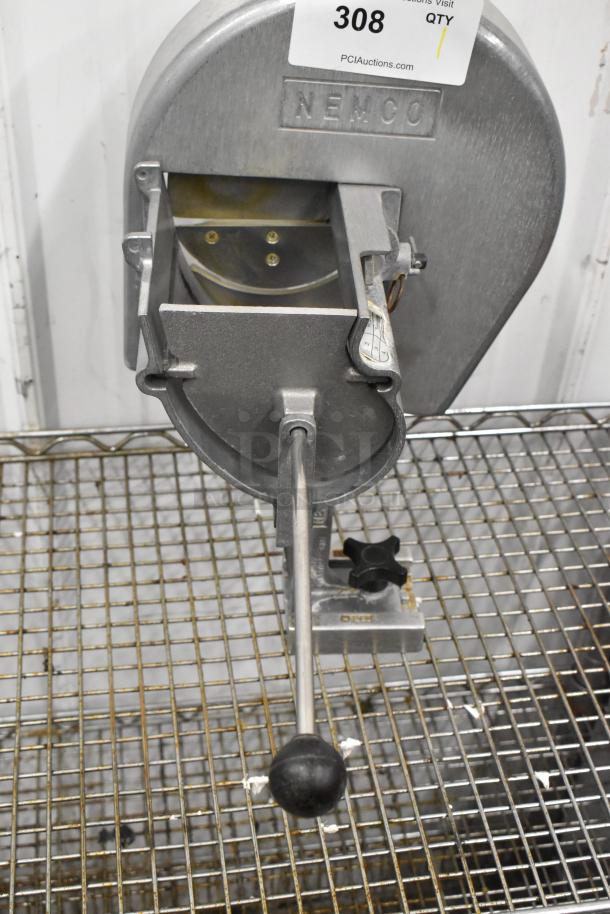 Nemco metal countertop vegetable slicer with manual lever, mounted on wire rack, showing slight wear, auction tag 308 visible.