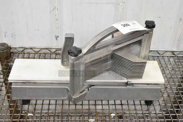 Nemco 56600 metal countertop tomato slicer, durable construction, used condition, visible auction tag, mounted on wire rack.