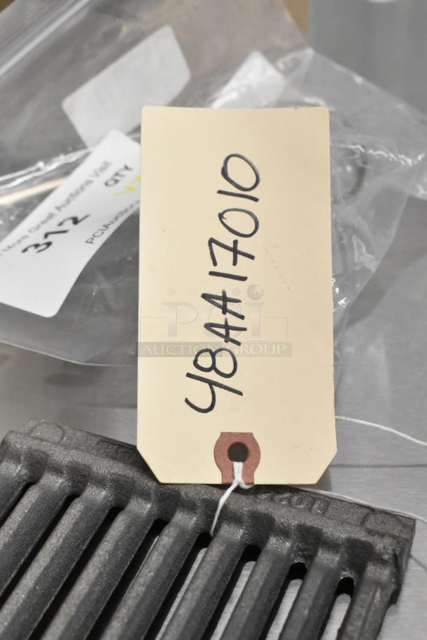 Cast iron grate with tag labeled 48AA17010, part of auction lot. Scratch and dent. Includes multiple brand new items.
