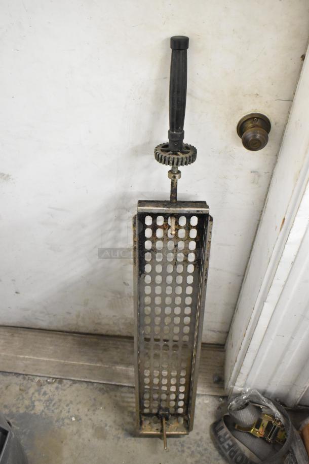 Metal skewers, basket type, for rotisserie oven, shown in gray trash can. Appears used, 12 in total, suitable for auction.