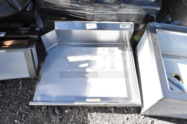 Brand new Regency 600CDT36R dish table, 16 gauge, 3' with right drainboard, scratch and dent, no legs, visible labels.