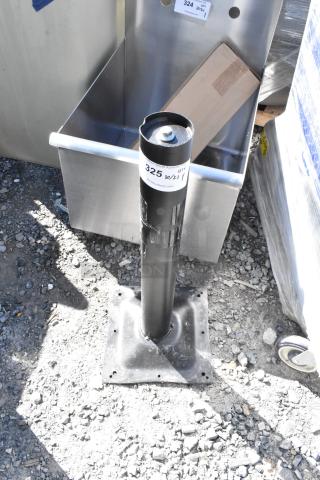 Black metal table base column, brand new with minor scratches and dents, auction lot 325 label visible.