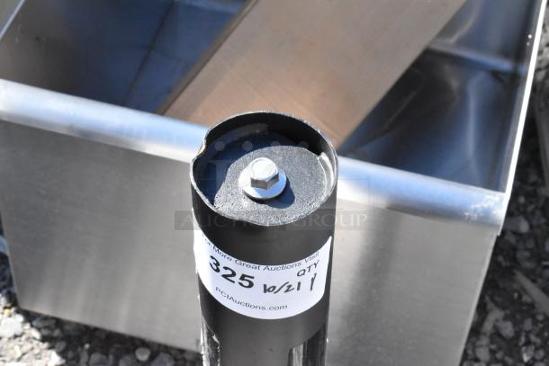 Brand new black metal table base column with scratch and dent. Visible tag shows quantity "325," from PCAuctions.com.