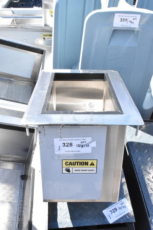 Brand new scratch and dent Regency 600DIIB1812 18" x 12" stainless steel drop-in ice bin with caution label.