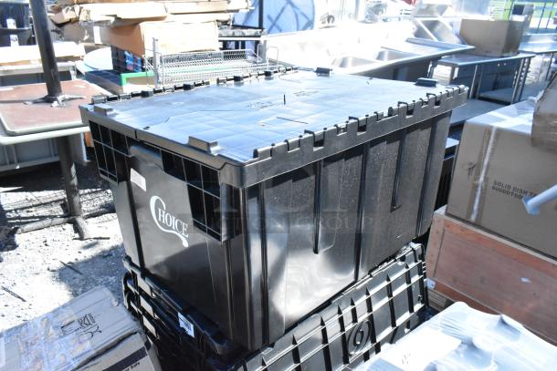 Black plastic storage bin labeled "Choice" in an industrial setting with boxes and equipment around. Scratches visible on surface.