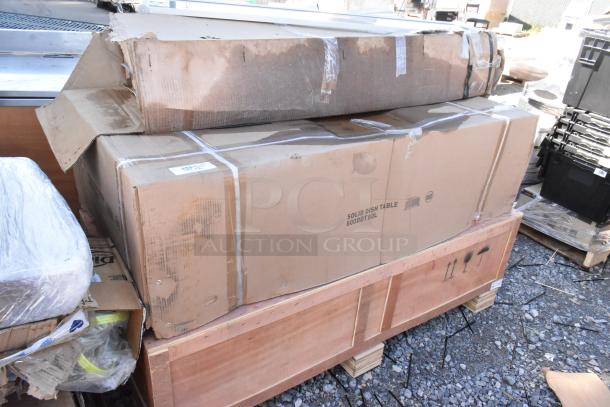 Three new items in boxes including a Regency 600DDT60L soiled dish table and Avantco countertop gas griddle, showing some damage.