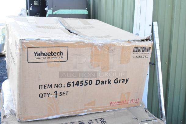Cardboard box labeled "Yaheetech, 614550 Dark Gray," quantity 1 set, marked fragile. Slight damage visible on top edge.