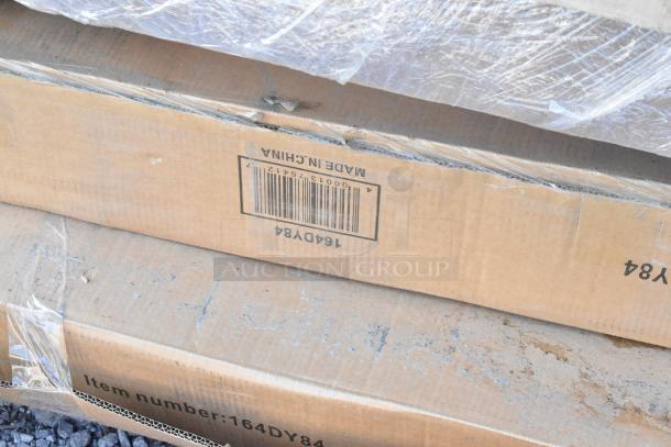 Cardboard box showing item number 164DY84, with partial packaging and markings, indicating new auction items.