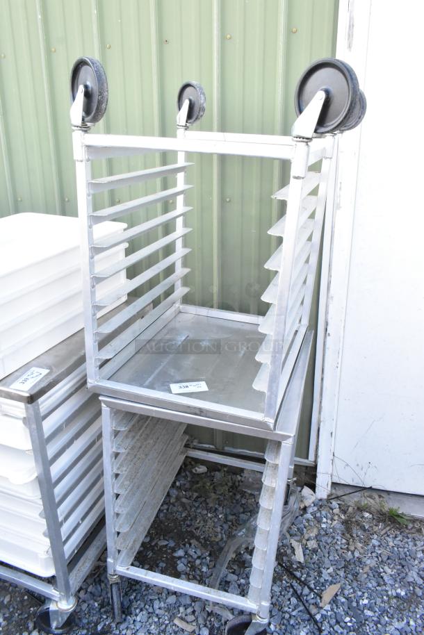 2 metal pan transport racks on commercial casters, industrial-grade, sturdy with slots for pans, light wear.