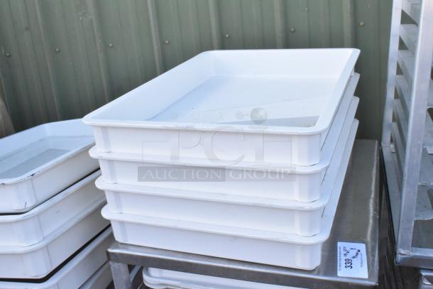 Metal pan transport rack with commercial casters featuring stacked white poly dough bins, used condition.