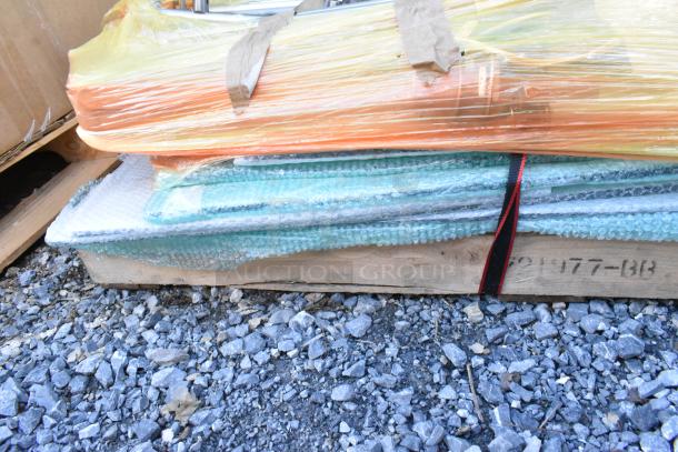Various items wrapped in bubble wrap and plastic on a pallet. Includes stainless steel pieces, packaged securely.