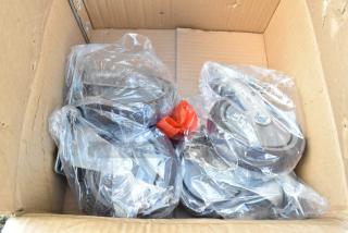 Box containing four commercial casters, each wrapped in plastic. New condition, heavy-duty design, suitable for industrial use.