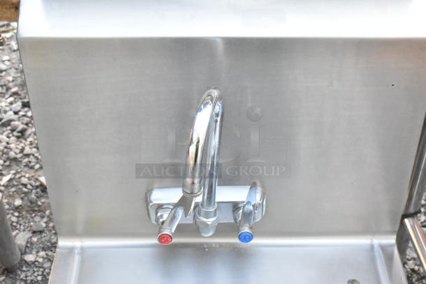 Stainless steel single bay wall mount sink with dual-handle faucet, featuring a clean and polished finish. Ideal for commercial use.