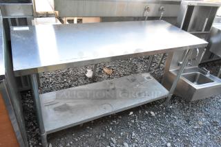 Stainless steel table with metal under shelf, used, showing minor surface scratches. Ideal for kitchen or industrial use.