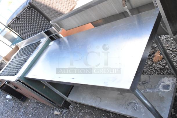 Stainless steel table with metal under shelf, used condition, sturdy construction, ideal for kitchen or industrial use.