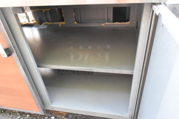 Duke SUBP-48 stainless steel 2-door work top counter, spacious interior, some visible wear, ideal for commercial use.