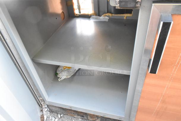Duke SUBP-48 stainless steel commercial 2-door work top counter, visible shelving, used condition, signs of wear.