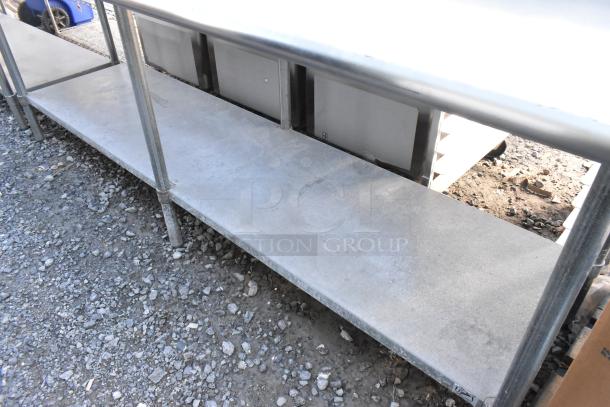 Stainless steel table with metal under shelf and back splash. Slight wear, suitable for kitchen or industrial use.