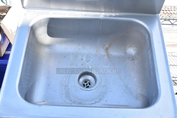 Stainless steel single bay wall mount sink with visible wear and stains, made for durability and easy installation.