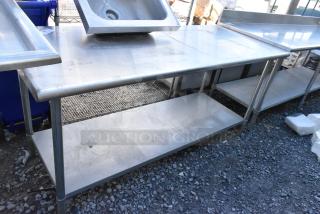 Stainless steel table with metal under shelf, used condition, features durable construction, visible surface wear.