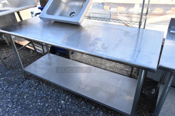 Stainless steel table with metal under shelf, includes an integrated sink, good condition, sturdy frame.