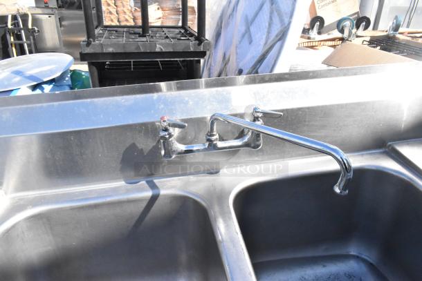 Stainless steel 2 bay sink with dual drain boards, faucet, dual handles; good condition, ideal for commercial kitchens.