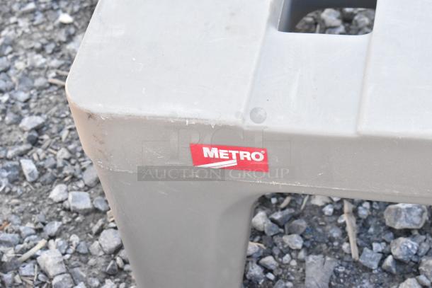 Two Metro gray poly dunnage racks; durable and sturdy with visible Metro logo; good used condition.