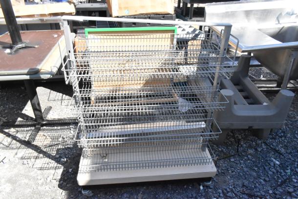 Metal display rack with multiple wire shelves on casters, suitable for retail, in good condition.