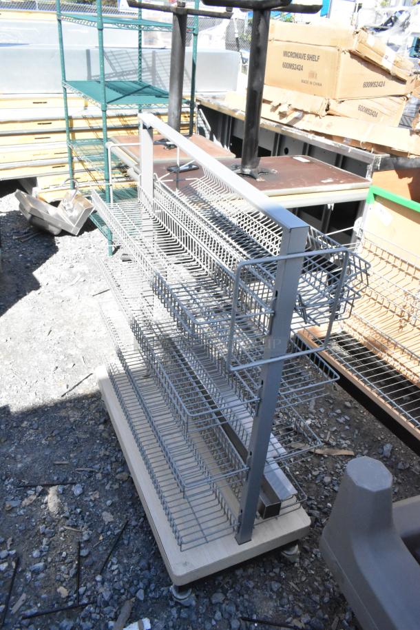 Metal display rack on casters with five wire shelves, ideal for retail use. In good condition, suitable for versatile display.