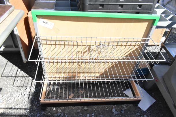 Three-tier metal display rack on casters, with wooden backing and green trim. Includes label "363 qty 1."