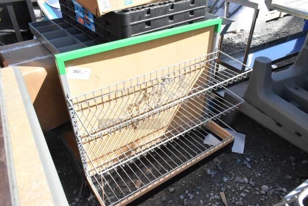 Metal display rack on casters, featuring two wire shelves and a green frame. Good condition with visible cardboard backing. Marked "363".