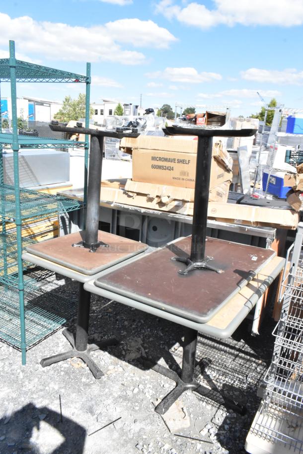 Four dining height tables with metal bases and square tops, shown in a used condition.